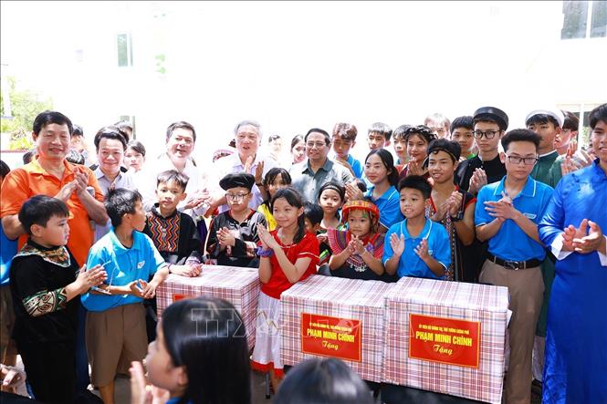 Thủ tướng Phạm Minh Chính tặng quà cho học sinh Trường Hy Vọng. Ảnh: Dương Giang-TTXVN
