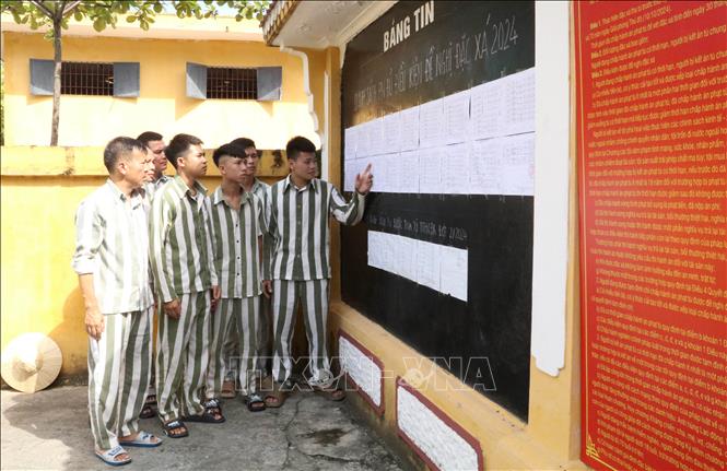 Phạm nhân tại Trại giam Ninh Khánh xem danh sách phạm nhân đủ điều kiện đề nghị đặc xá năm 2024 được niêm yết công khai tại bảng tin. Ảnh: Hải Yến - TTXVN
