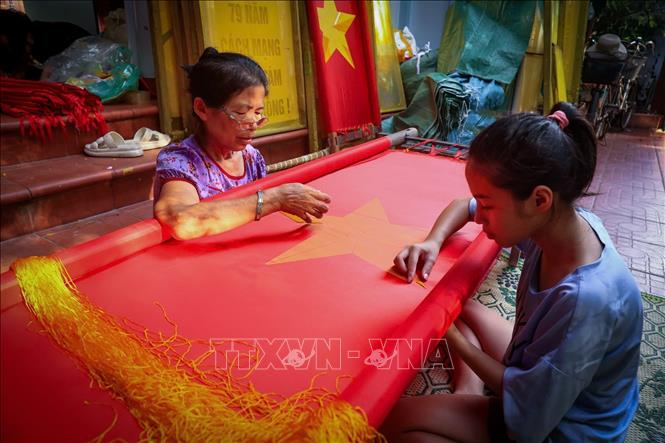 Trải qua 80 năm, nghề may cờ Tổ quốc vẫn được các thế hệ người làng Từ Vân giữ gìn và phát triển. Ảnh: Phạm Tuấn Anh - TTXVN