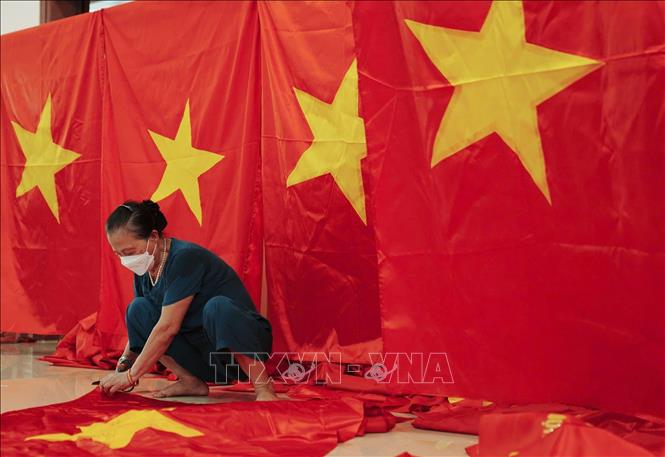 Ý thức được tầm quan trọng của cờ Tổ quốc, những người thợ luôn đặt hết tâm mình trong từng đường kim mũi chỉ, từng công đoạn để làm ra lá cờ. Ảnh: Phạm Tuấn Anh - TTXVN
