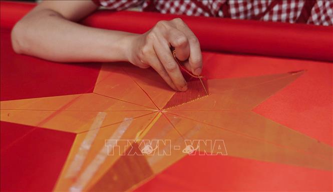 Từng đường kim, mũi chỉ được thêu lên cờ phải đạt độ chính xác rất cao. Ảnh: Phạm Tuấn Anh - TTXVN
