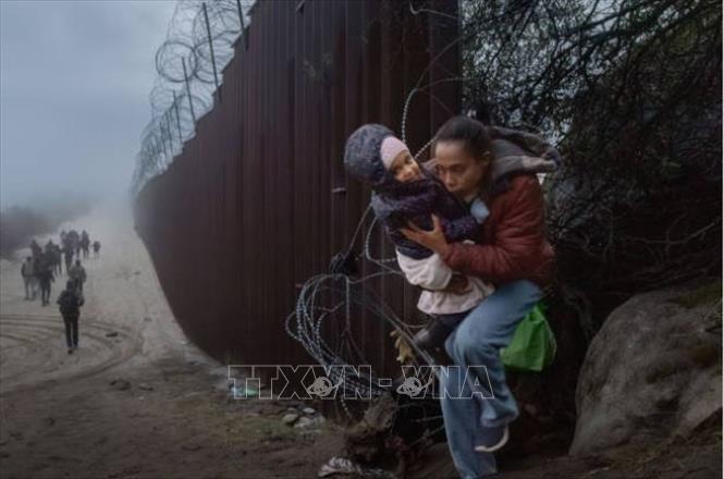 Người di cư vượt qua hàng rào biên giới Mỹ-Mexico tại khu vực Jacumba, bang California (Mỹ) ngày 22/12/2023. Ảnh: Getty Images/TTXVN