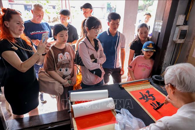 Du khách tham quan, xin chữ tại Khu di tích Quốc gia đặc biệt Văn Miếu - Quốc Tử Giám. Ảnh: Hoàng Hiếu - TTXVN