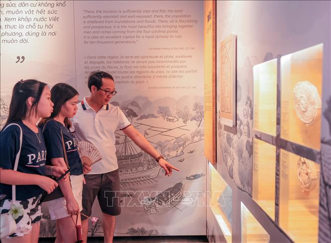 Du khách tìm hiểu về lịch sử phát triển của Khu di tích Quốc gia đặc biệt Văn Miếu - Quốc Tử Giám. Ảnh: Hoàng Hiếu - TTXVN