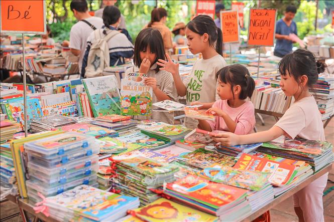 Trẻ em lựa chọn những cuốn sách hay, phù hợp với lứa tuổi tại khu quầy sách Hồ Văn - Văn Miếu. Ảnh: Hoàng Hiếu - TTXVN