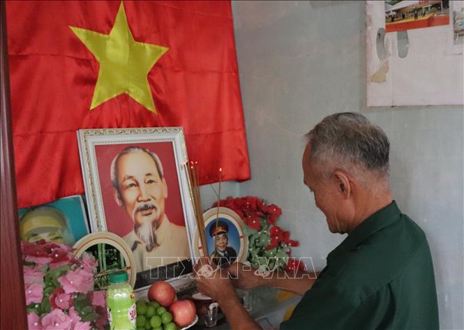 Cựu chiến binh Trần Văn Oanh thắp hương lên bàn thờ Bác. Ảnh: Hồng Thái - TTXVN