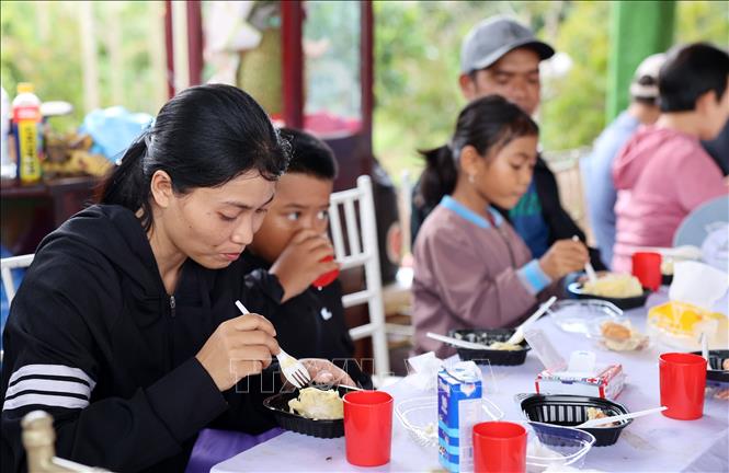 Du khách thưởng thức sầu riêng miễn phí. Ảnh: Hoài Thu - TTXVN