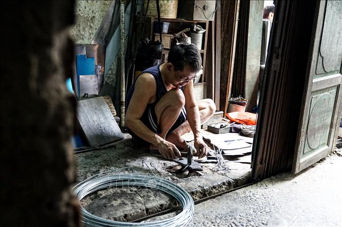 Tourists passing the street can hear the sounds of hammer striking against metals from early morning until late at night, the sounds that keep the traditional craft of tinsmiths alive in the modern days. VNA Photo: Khánh Hoà 