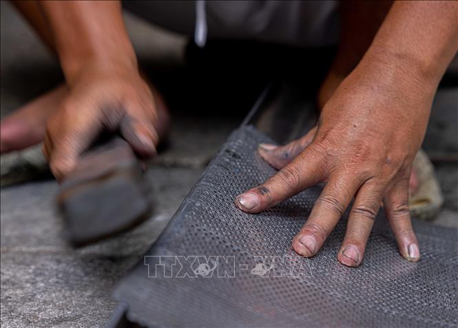 Tourists passing the street can hear the sounds of hammer striking against metals from early morning until late at night, the sounds that keep the traditional craft of tinsmiths alive in the modern days. VNA Photo: Hoàng Hiếu 