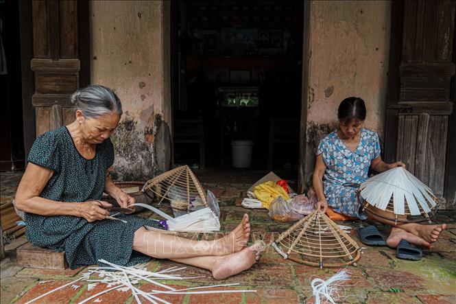 Chiếc nón lá truyền thống tưởng chừng đơn giản nhưng đòi hỏi người thợ làm nón phải có kinh nghiệm lâu năm mới tạo ra thành phẩm đẹp mắt. Ảnh: Phạm Tuấn Anh-TTXVN