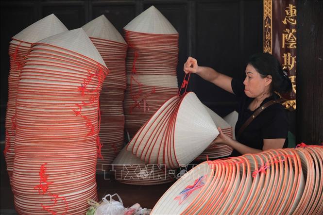 Dưới bàn tay tài hoa, tỉ mỉ, nhẫn nại và chính xác của người nghệ nhân, những chiếc nón làng Chuông chính hiệu được ra đời với các đặc điểm bền, chắc, khoẻ, đẹp và thanh, được tiêu thụ ở khắp các vùng miền trong cả nước. Ảnh: Ngọc Liên-TTXVN