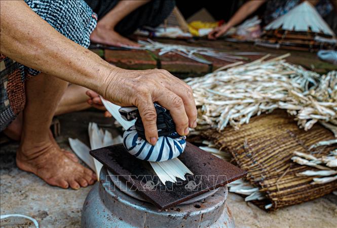 Lá sau khi hun được thả ra ngoài không khí rồi phơi sương cho mềm, mịn, là phẳng, dễ lợp nón. Ảnh: Phạm Tuấn Anh-TTXVN