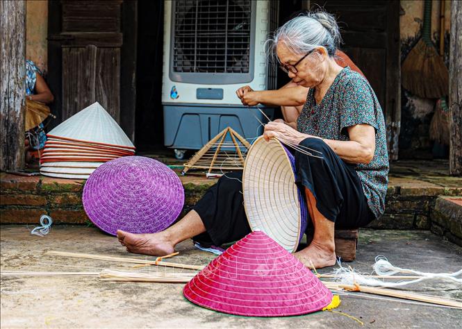 Làng Chuông hiện nay đang phát triển thêm sản phẩm nón lợp lụa, phù hợp với thị hiếu của người dùng. Ảnh: Phạm Tuấn Anh-TTXVN