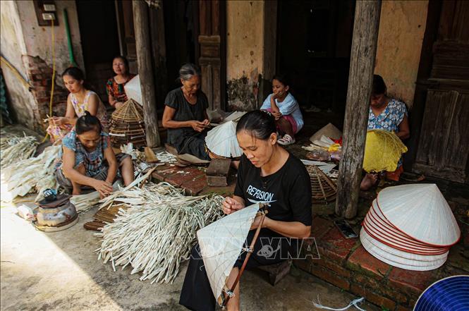 Những người thợ làng Chuông cần mẫn, tỉ mỉ tạo ra những chiếc nón lá truyền thống được người dùng yêu thích. Ảnh: Phạm Tuấn Anh-TTXVN