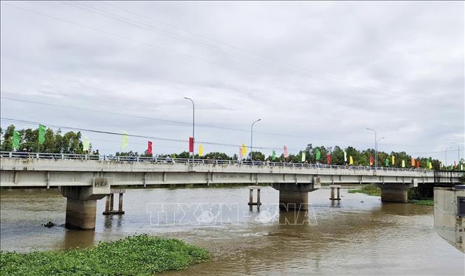 Người dân thị xã Tịnh Biên, An Giang theo dõi vận hành mở 2 cống Tha La, Trà Sư nhằm điều tiết lũ cho vùng Tứ giác Long Xuyên. Ảnh: Thanh Sang-TTXVN