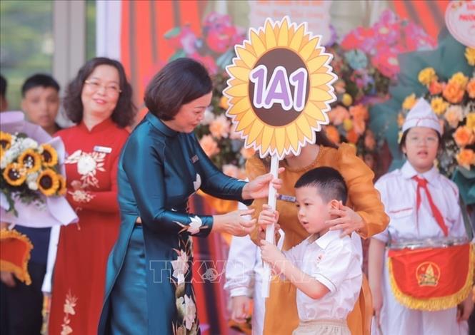 Hiệu trưởng Trường Tiểu học Gia Quất (quận Long Biên) trao biển lớp cho học sinh lớp 1. Ảnh: Minh Quyết - TTXVN