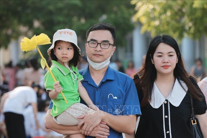 Bố và mẹ cùng đưa bé đến dự khai giảng trong ngày đầu đến trường. Ảnh: Minh Quyết - TTXVN