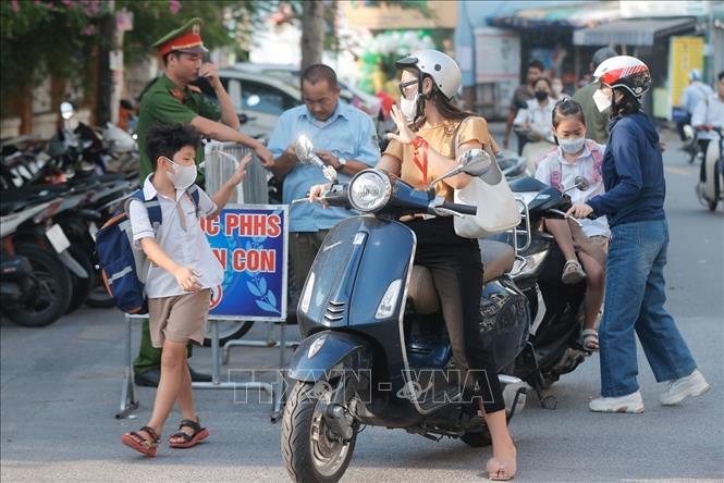 Học sinh được bố mẹ đưa đến dự khai giảng tại Trường Tiểu học Gia Quất, quận Long Biên. Ảnh: Minh Quyết - TTXVN