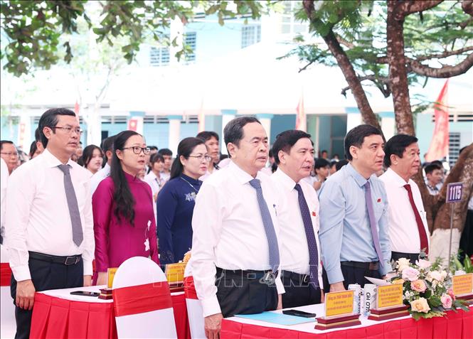 Chủ tịch Quốc hội Trần Thanh Mẫn và các đại biểu cùng các thầy cô giáo, học sinh Trường THPT Phạm Hùng thực hiện nghi thức chào cờ. Ảnh: Thống Nhất - TTXVN