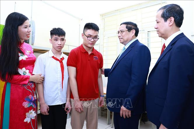 Thủ tướng Phạm Minh Chính động viên học sinh khiếm thị đang học tại Trường Phổ thông cơ sở Nguyễn Đình Chiểu. Ảnh: Dương Giang-TTXVN