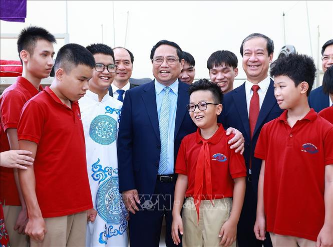 Thủ tướng Phạm Minh Chính với học sinh khiếm thị đang học tại Trường Phổ thông cơ sở Nguyễn Đình Chiểu. Ảnh: Dương Giang-TTXVN