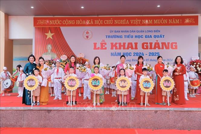 Hiệu trưởng trường tiểu học Gia Quất (Long Biên) trao biển lớp cho học sinh khối 1. Ảnh: Minh Quyết - TTXVN
