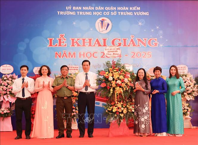Lãnh đạo Quận ủy, UBND quận Hoàn Kiếm tặng hoa chúc mừng trường THCS Trưng Vương khai giảng năm học mới. Ảnh: Thanh Tùng -  TTXVN