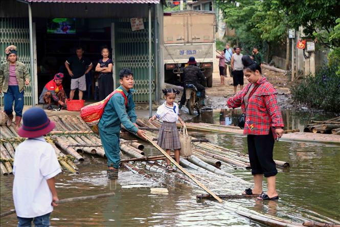 Học sinh bản Phiêng Nghè, xã Chiềng Đen, thành phố Sơn La (Sơn La) được phụ huynh chở bằng bè tre đến dự Lễ khai giảng năm học mới 2024 - 2025. Ảnh: Quang Quyết - TTXVN