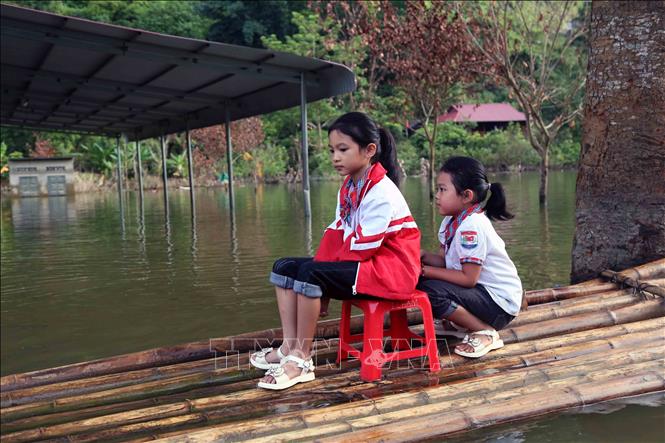 Học sinh bản Phiêng Nghè, xã Chiềng Đen, thành phố Sơn La (Sơn La) được phụ huynh chở bằng bè tre để dự Lễ khai giảng năm học mới 2024 - 2025. Ảnh: Quang Quyết - TTXVN