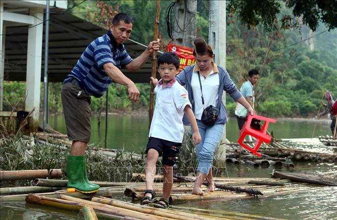 Học sinh bản Phiêng Nghè, xã Chiềng Đen, thành phố Sơn La (Sơn La) được phụ huynh chở bằng bè tre đến dự Lễ khai giảng năm học mới 2024 - 2025. Ảnh: Quang Quyết - TTXVN