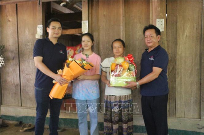 Đại diện quỹ học bổng “Tiếp sức bác sĩ đến trường” của Thẩm mỹ Doãn Lâm trao hoa và quà chúc mừng cho em Thò Ý Cu. Ảnh: Bích Huệ - TTXVN