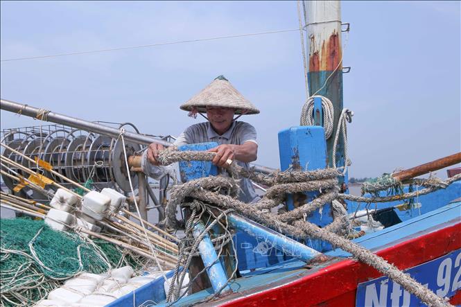 Ngư dân chằng buộc tàu thuyền trước khi bão số 3 đổ bộ đất liền. Ảnh: Công Luật - TTXVN