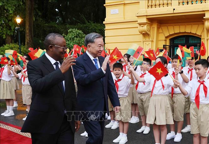 Party General Secretary, State President To Lam and President of Guinea-Bissau Umaro Sissoco Embalo with children of Hanoi at the welcome ceremony. VNA Photo: Minh Đức