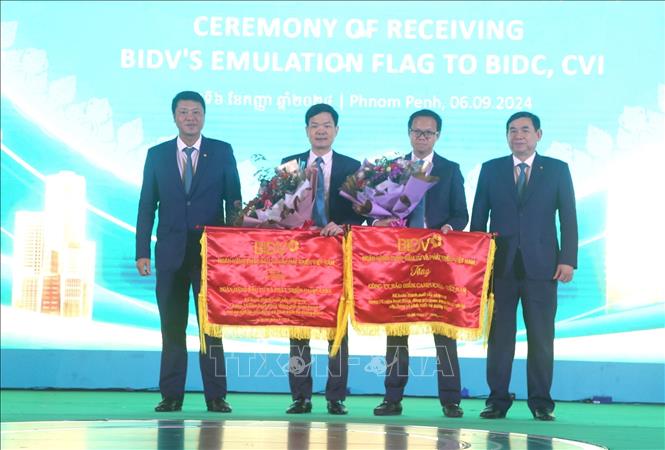 Lãnh đạo Ngân hàng Đầu tư và Phát triển Việt Nam (BIDV) trao tặng Cờ thi đua cho tập thể BIDC. Ảnh: Hoàng Minh- PV TTXVN tại Campuchia 