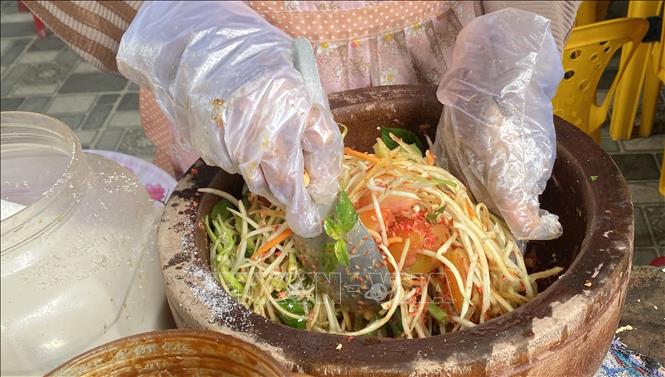 Các nguyên liệu chế biến món đu đủ đâm được bỏ vào cối. Ảnh: Công Mạo-TTXVN