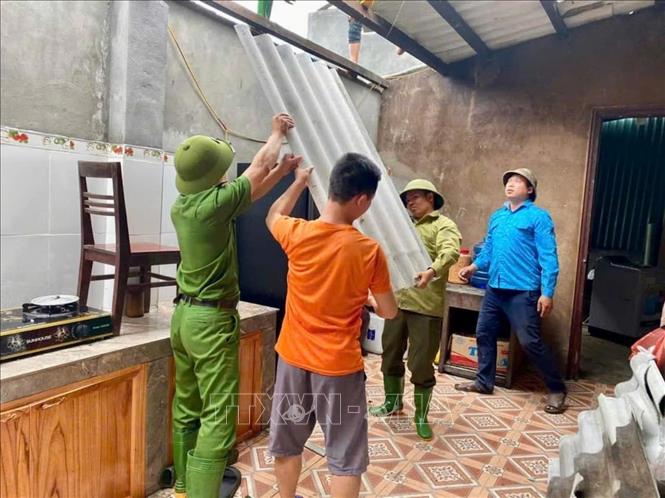 Lực lượng tại chỗ tham gia lợp lại mái nhà cho các hộ gia đình bị thiệt hại tại huyện Văn Yên. Ảnh: TTXVN phát