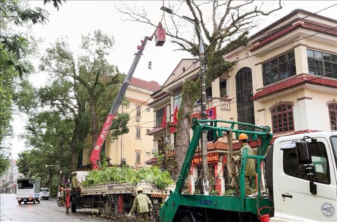 Lực lượng chức năng cắt tỉa cành cây tại thành phố Lạng Sơn để đảm bảo an toàn. Ảnh: Văn Đạt - TTXVN

