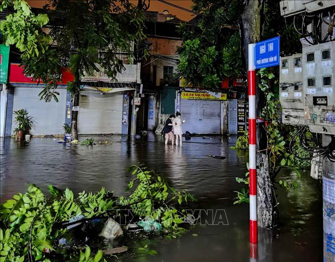Người dân lội nước về nhà. Ảnh: Thanh Tùng - TTXVN 