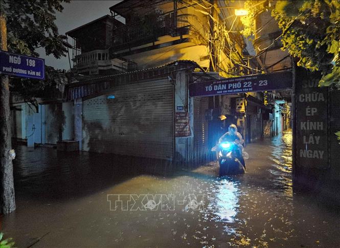 Người dân lội nước về nhà. Ảnh: Thanh Tùng - TTXVN 