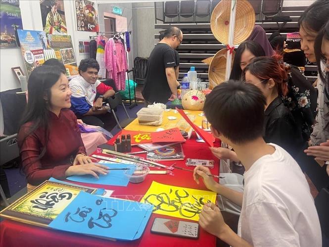 Cô giáo Nguyễn Thụy Thiên Hương (bên trái) với các sinh viên của trường Đại học Malaya (UM) trong tiết học tìm hiểu và học viết Thư pháp Việt. Ảnh: Hằng Linh-PV TTXVN tại Kuala Lupur