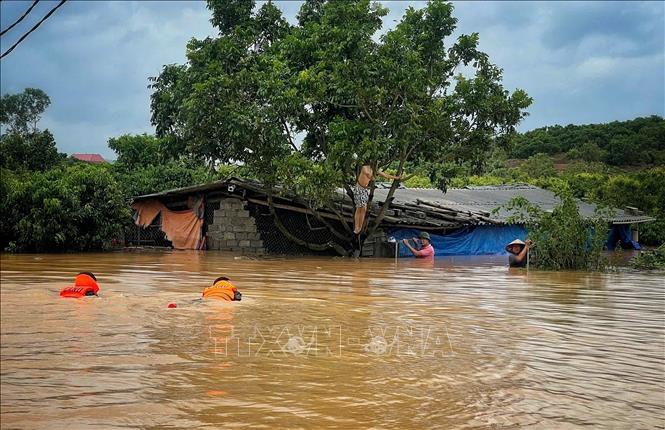 Công an huyện Sơn Động cứu hộ người dân bị mắc kẹt trong vùng lũ. Ảnh: TTXVN phát 