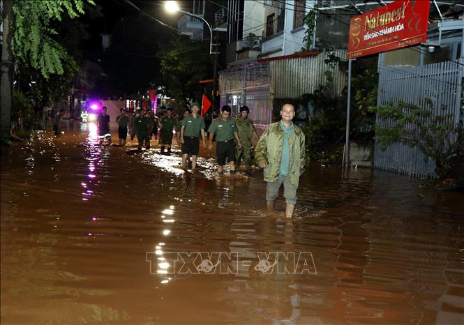 Lực lượng Công an thành phố Lạng Sơn, Công an phường Chi Lăng tuyên truyền, kê gọi, hỗ trợ nhân dân di chuyển người và đồ đạc đến nơi an toàn. Ảnh: Văn Đạt - TTXVN