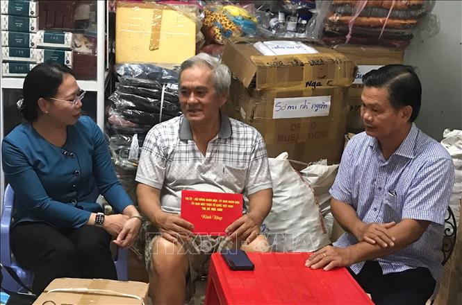 Lãnh đạo Thị ủy, UBND thị xã Ngã Năm động viên và hỗ trợ ông Nguyễn Bá Tùng, chủ siêu thị bị cháy. Ảnh: Tuấn Phi - TTXVN