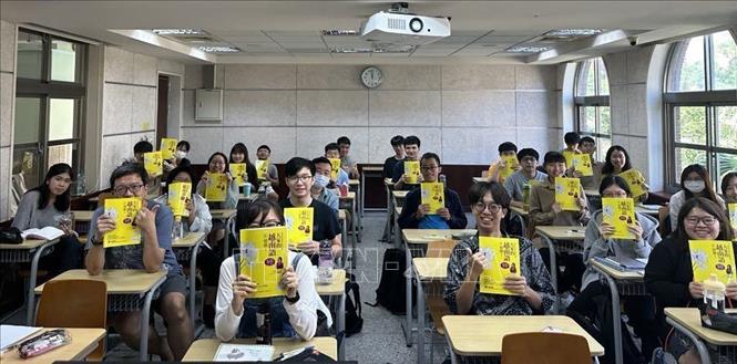 Sinh viên Đại học Đài Loan (Trung Quốc) với cuốn giáo trình học tiếng Việt của cô Nguyễn Thị Liên Hương. Ảnh: TTXVN phát