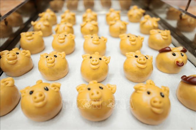 Những chiếc bánh hình con thú sinh động, ngộ nghĩnh được đưa vào lò nướng, khi xong bánh sẽ đạt độ căng tròn, màu vàng bắt mắt. Ảnh: Minh Quyết – TTXVN