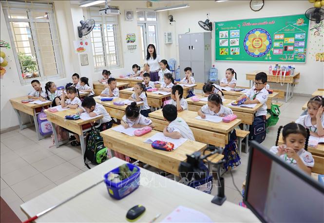 Học sinh lớp 1 tiểu học Thăng Long (quận Hoàn Kiếm) trong ngày đầu trở lại trường khi cơn bão số 3 đi qua. Ảnh: Thanh Tùng - TTXVN 