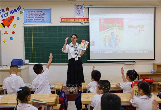 Học sinh lớp 1 tiểu học Thăng Long (quận Hoàn Kiếm) trong ngày đầu trở lại trường khi cơn bão số 3 đi qua. Ảnh: Thanh Tùng - TTXVN