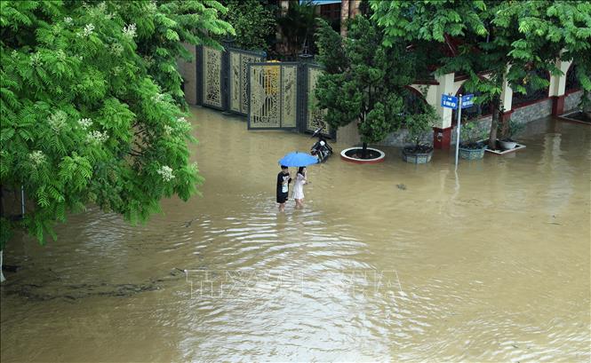Đường Phạm Văn Xảo, phường Lào Cai, thành phố Lào Cai bị lũ tràn vào, ngập trong biển nước lúc 11g30 ngày 9/9 khiến người dân đi lại khó khăn. Ảnh: Quốc Khánh - TTXVN
