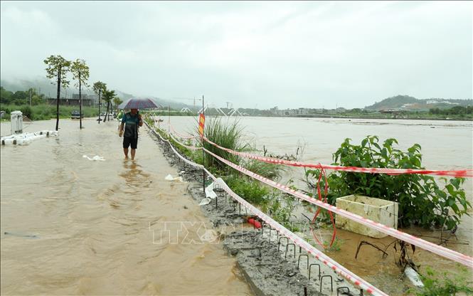 Mức nước sông Hồng dâng cao gần bằng bờ kè thành phố Lào Cai khiến người dân di chuyển khó khăn. Ảnh: Quốc Khánh - TTXVN