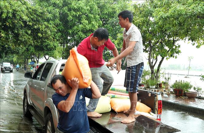 Người dân thành phố Lào Cai di chuyển lương thực đến nơi an toàn. Ảnh: Quốc Khánh - TTXVN